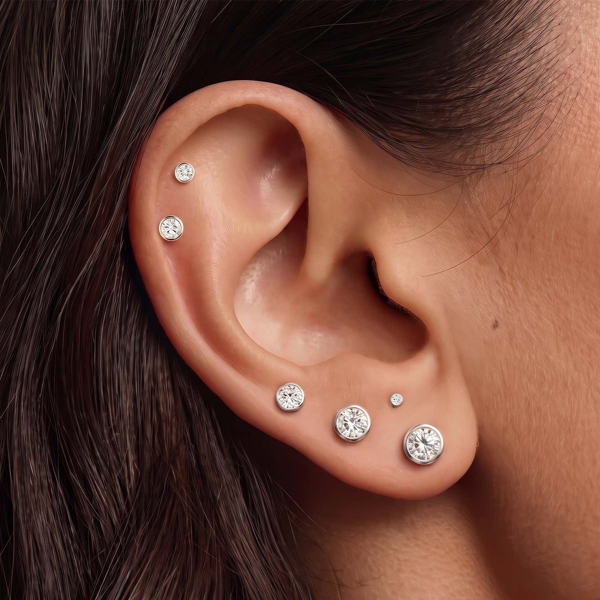 14K White Gold Bezel Studs in sizes 1.5mm to 6mm worn on the ear
