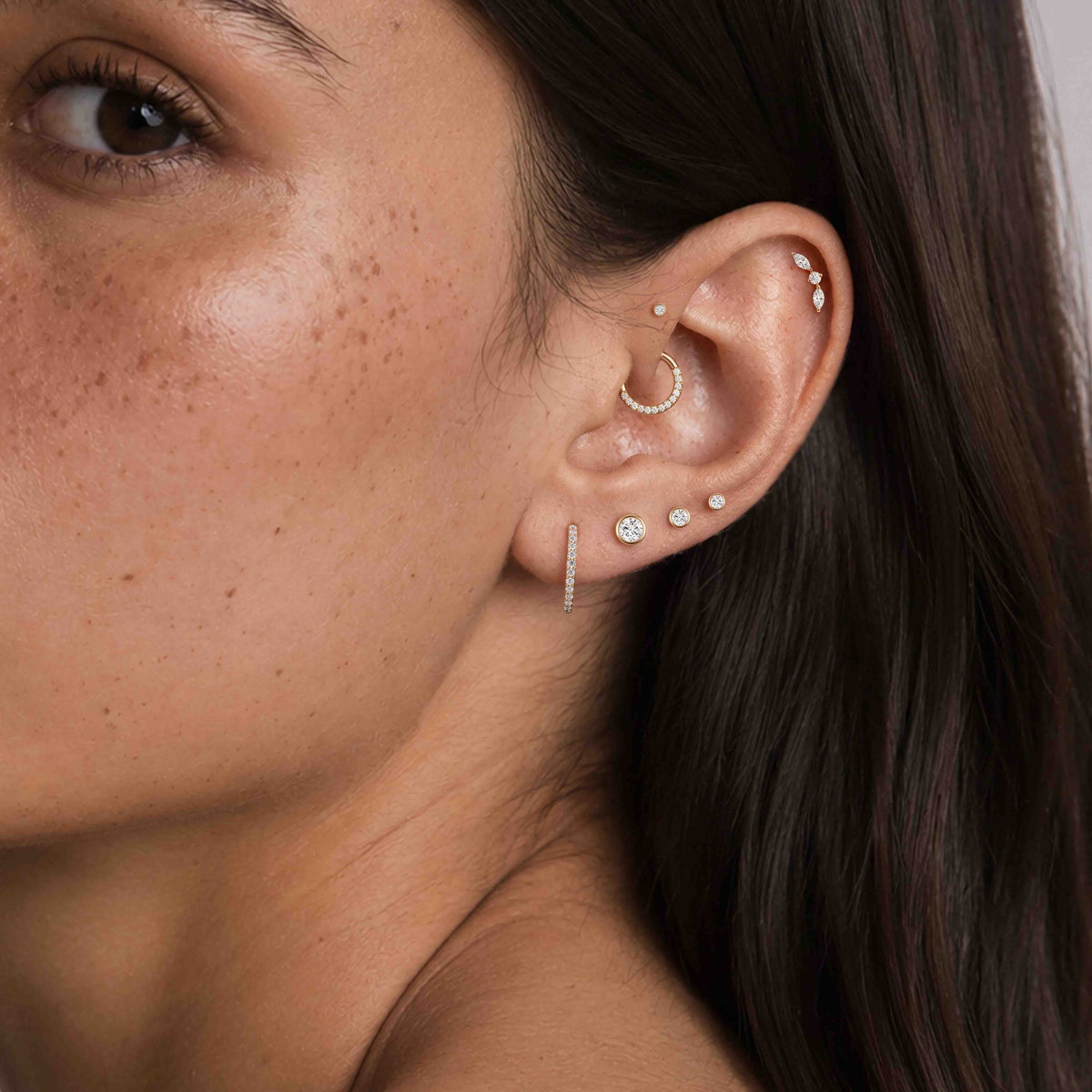 14K Yellow Gold Bezel Studs worn in an ear piercing stack, wide view