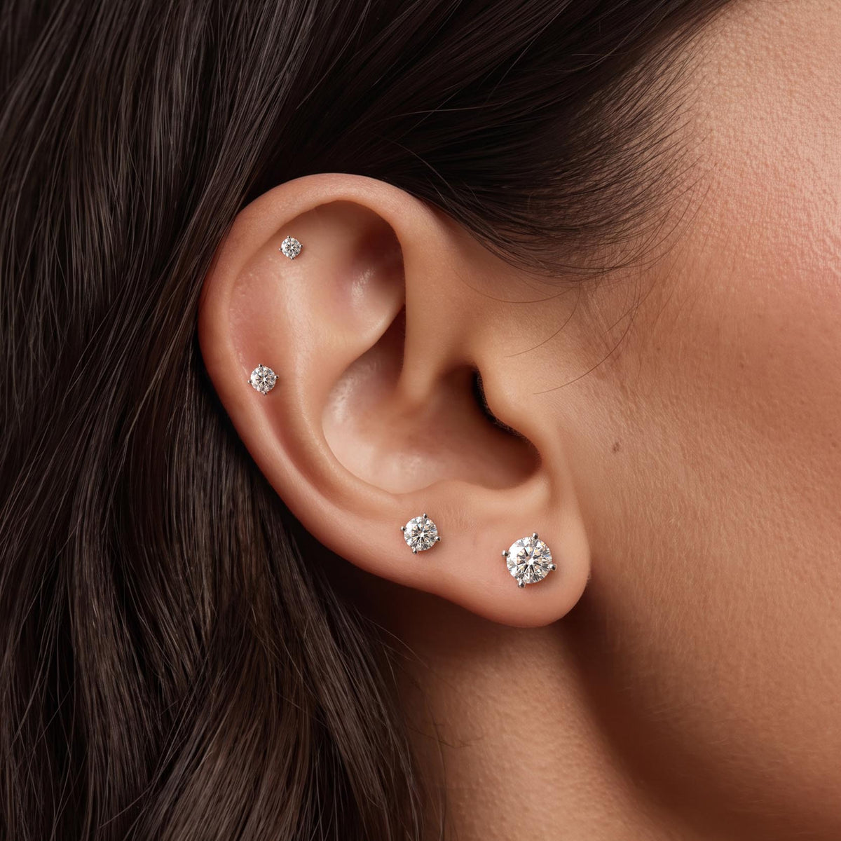 Classic 4-Prong Setting White Gold flat back studs worn in a cartilage and lobe piercing stack