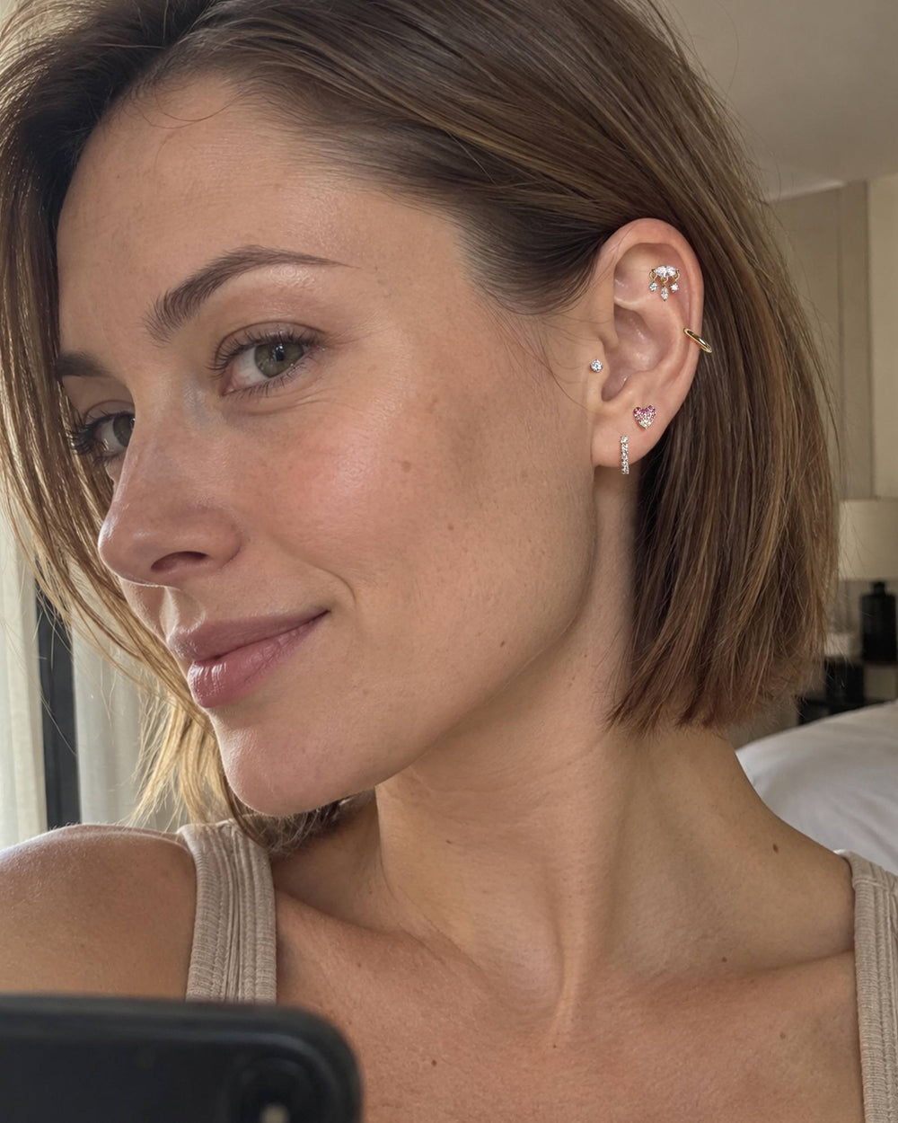Side profile with a delicate heart stud and cartilage stack